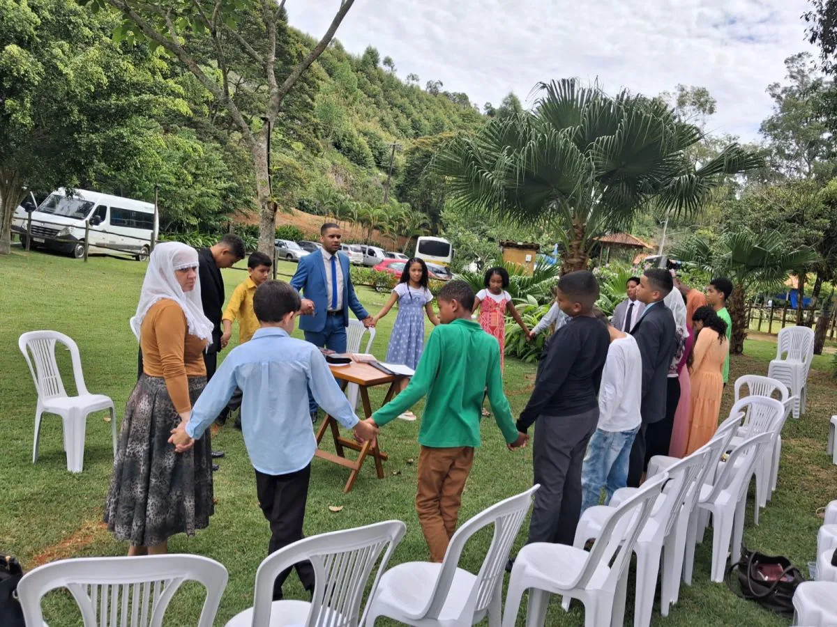 Grupo em roda no gramado durante evento