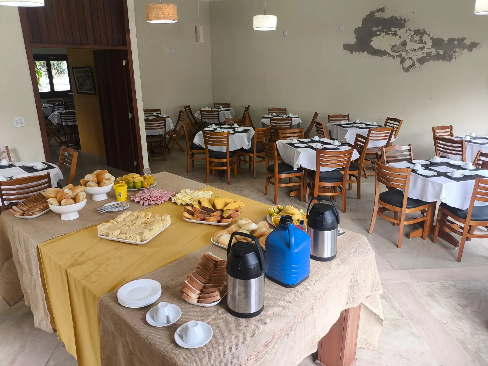 Mesa de café com garrafas térmicas e bolos