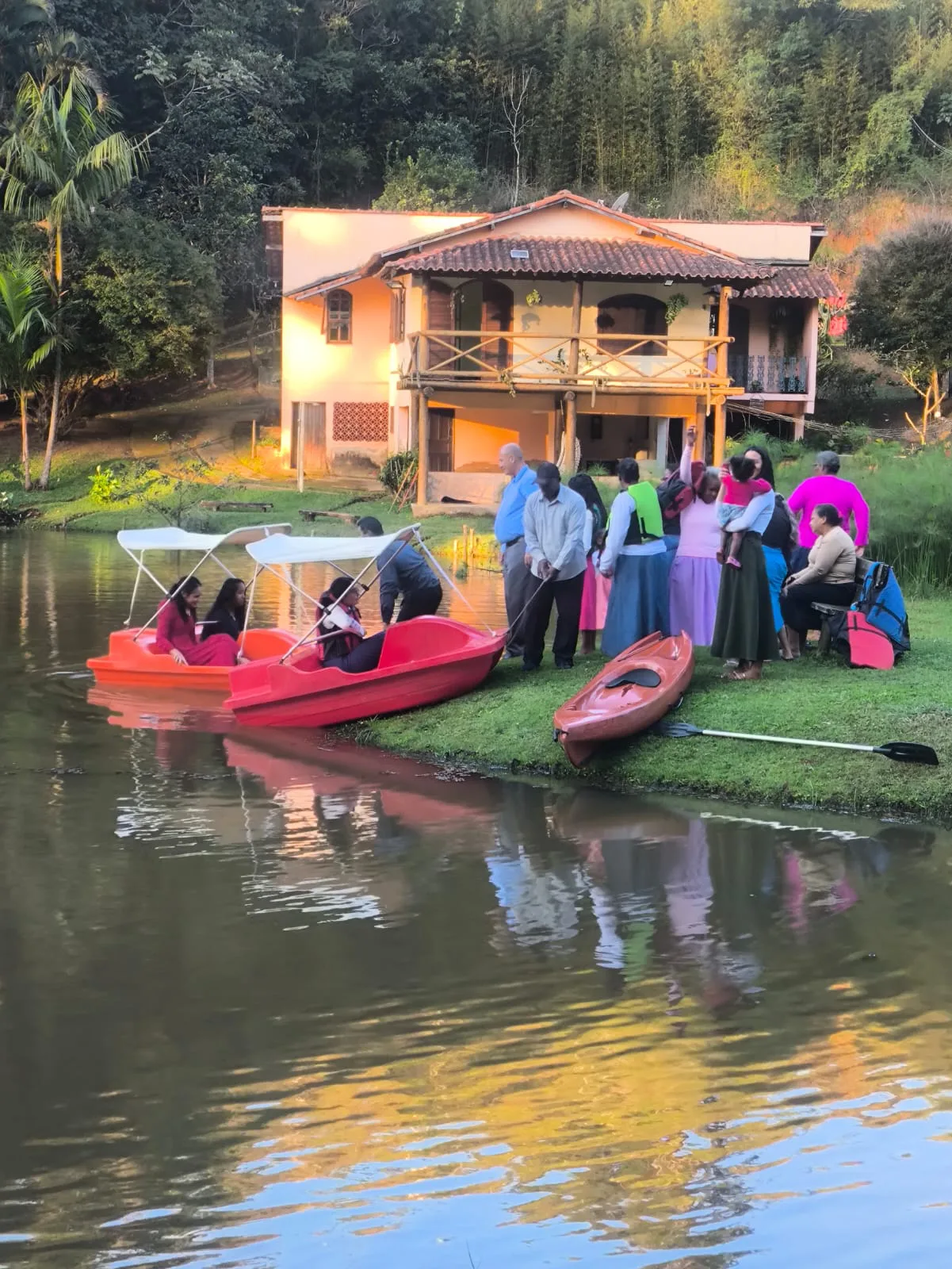 Pedalinhos com visitantes no lago em frente ao chalé