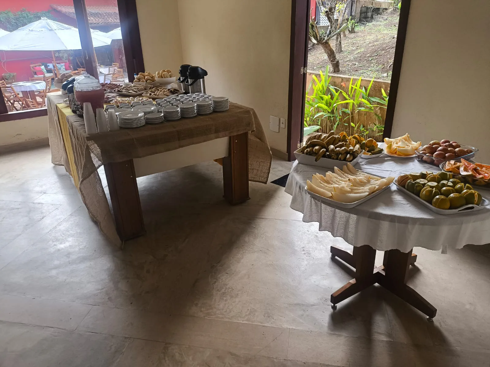Mesa de café com bolo e garrafas térmicas