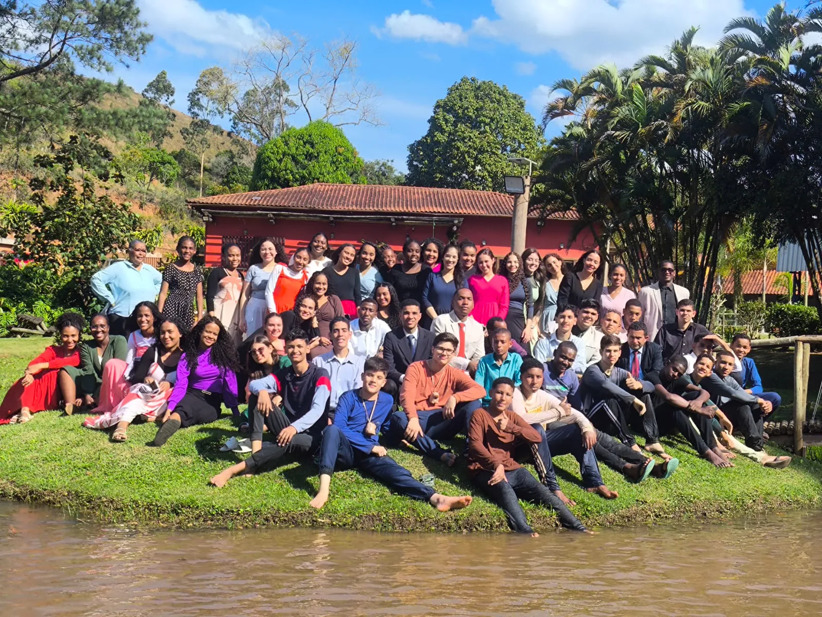 Grupo de jovens reunido para foto na beira do lago