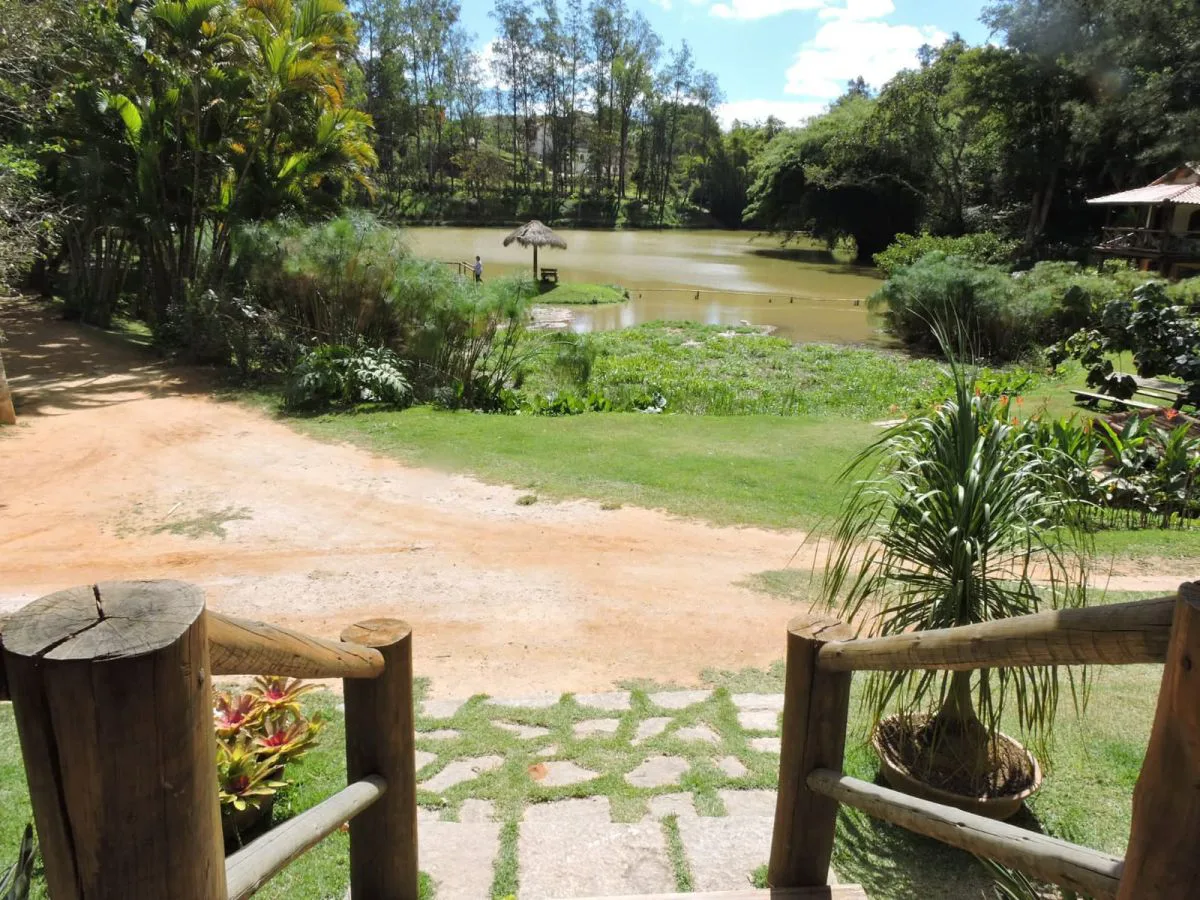 Caminho de terra com cerca rústica até o lago