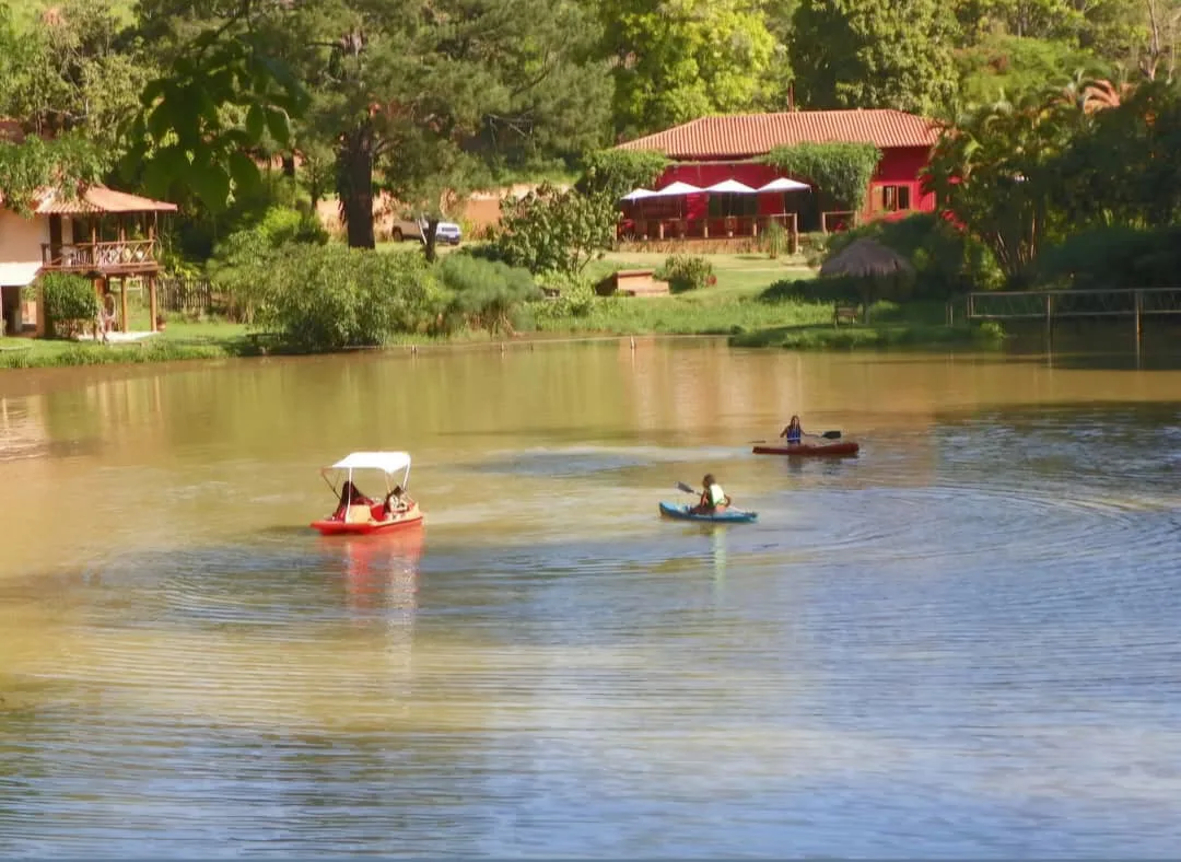 Lago com pedalinhos e chalé vermelho ao fundo