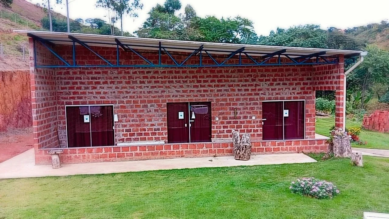Prédio dos alojamentos em tijolo aparente cercado de gramado