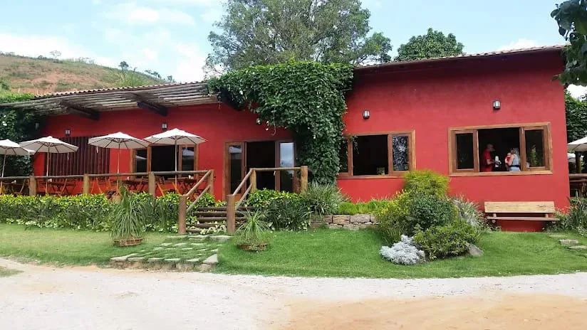 Chalé vermelho com varanda e jardim